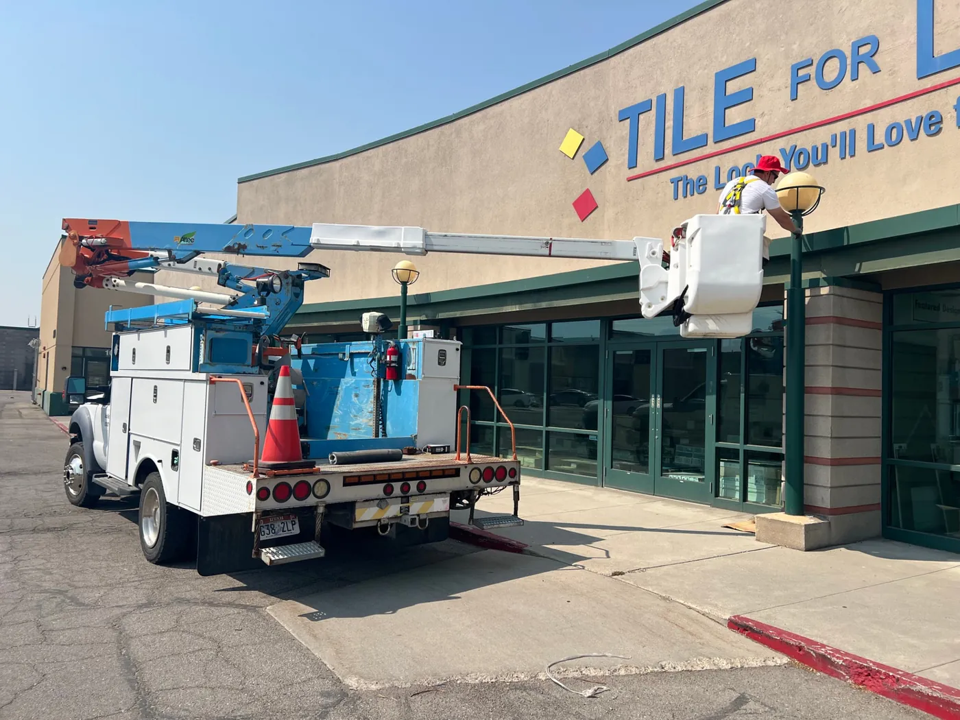 Tactical Electrical Services bucket truck servicing exterior lighting at a Utah commercial building
